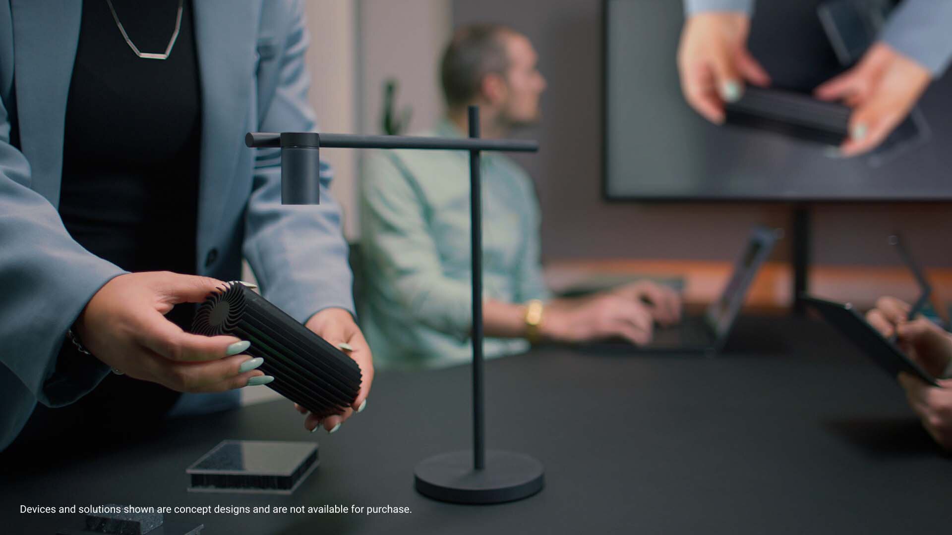 Picture of a woman hands showing a product through the movable wireless web camera concept above an office table.