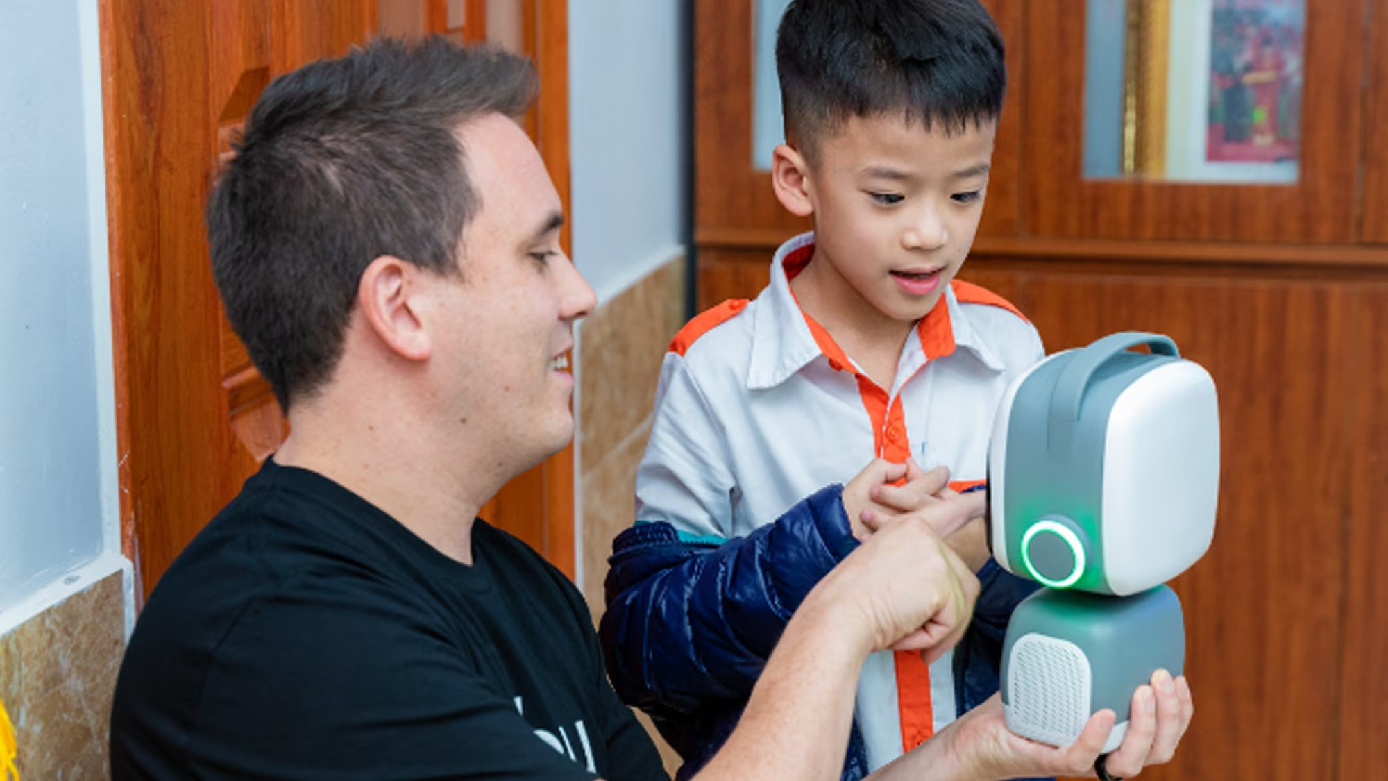 Image of two people playing with a robot