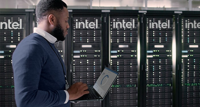 Man in front of Intel servers holding a Dell laptop.