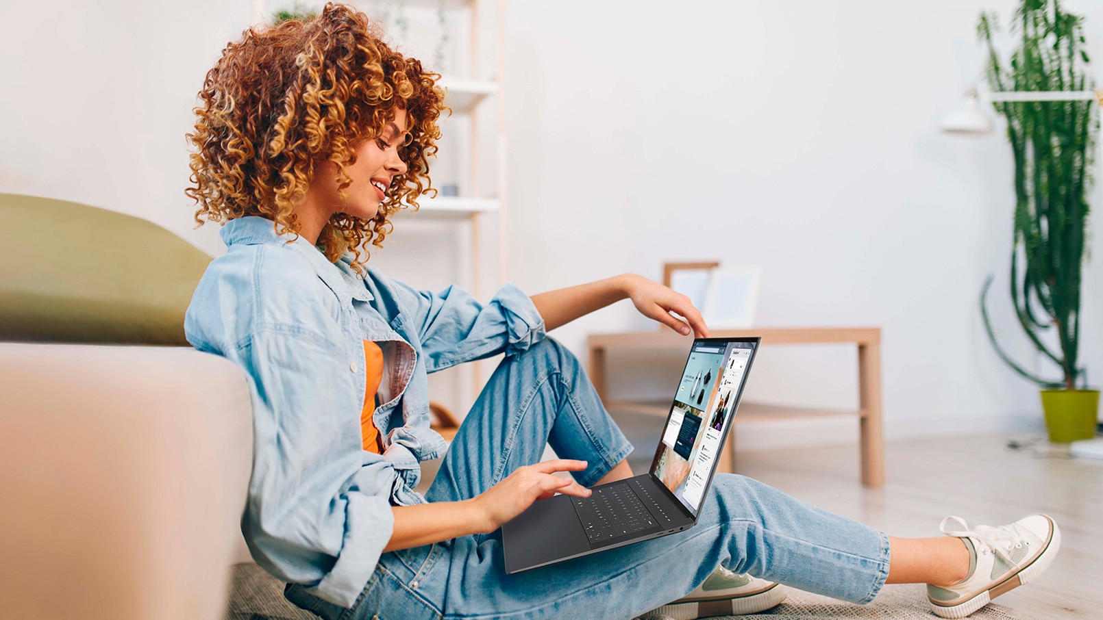 Smiling woman working on laptop in cozy living room.