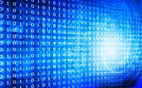 Digital image of binary code against a blue background, with a spiral galaxy-like structure on on the right side, behind the code.