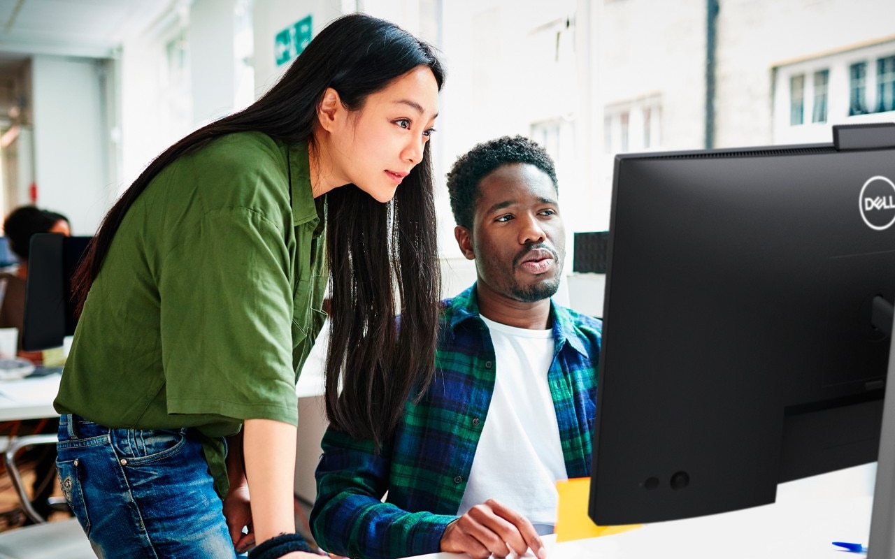 Female and male work colleagues collaborate on video conference using Dell 27" C2722DE monitor and computer equipment.