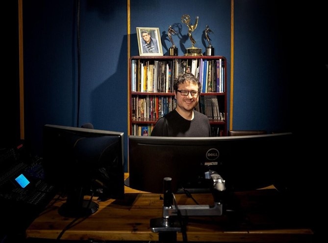 Cory Choy filmmaker working at his desk with a Dell widescreen monitor