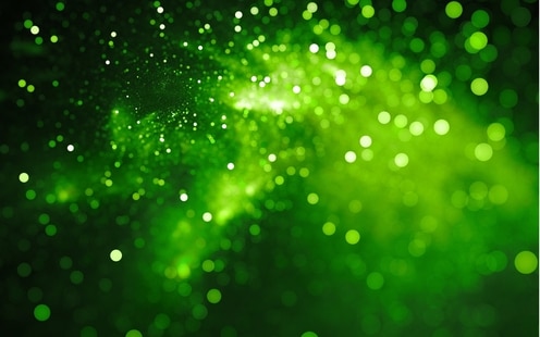 A bright green nebula cloud backlit against a black background.