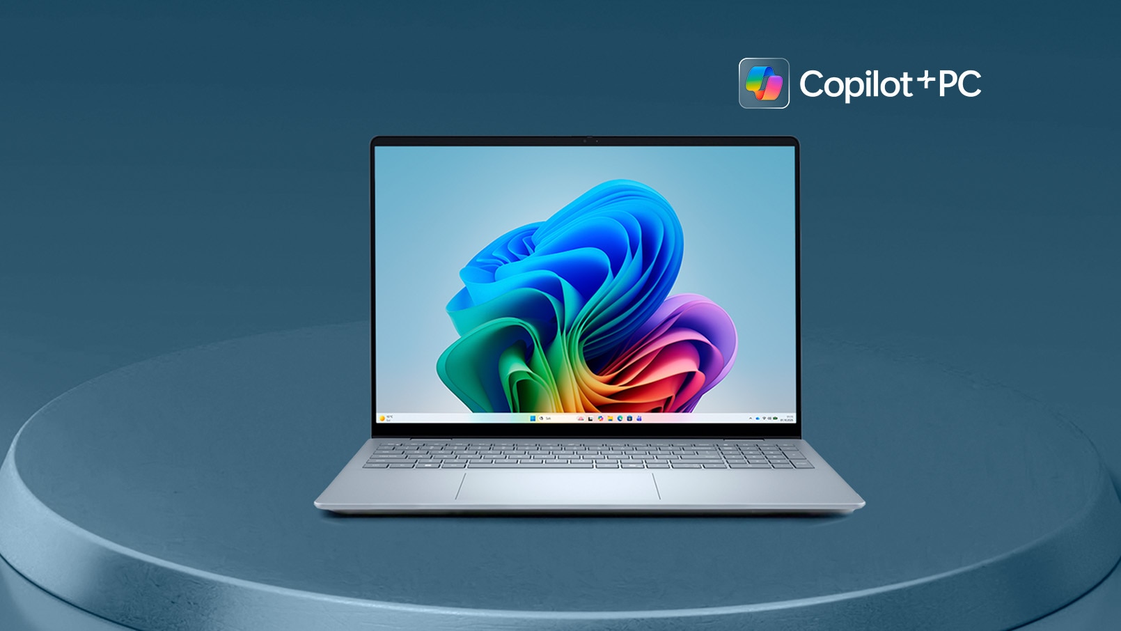 Open Dell Copilot+ PC laptop on a round blue podium with Windows wallpaper and branding.