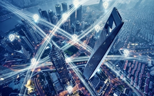 Digital image of a city skyline from a high aerial view, with network connections between various locations.