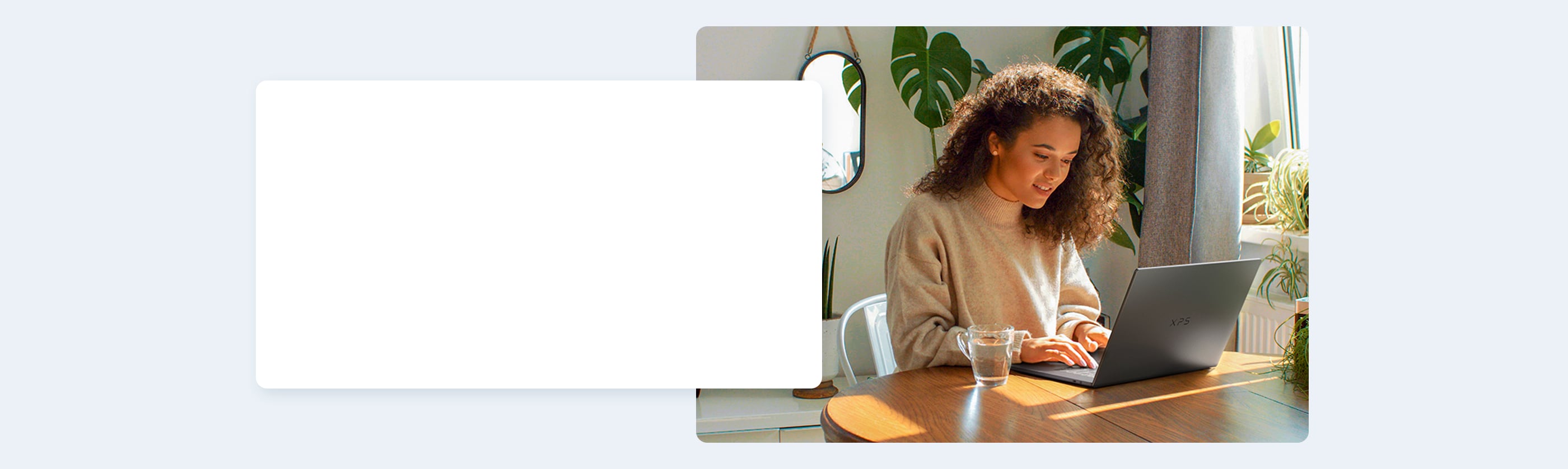 Woman Sitting at her Kitchen Table using the XPS 16 DA16260 Laptop