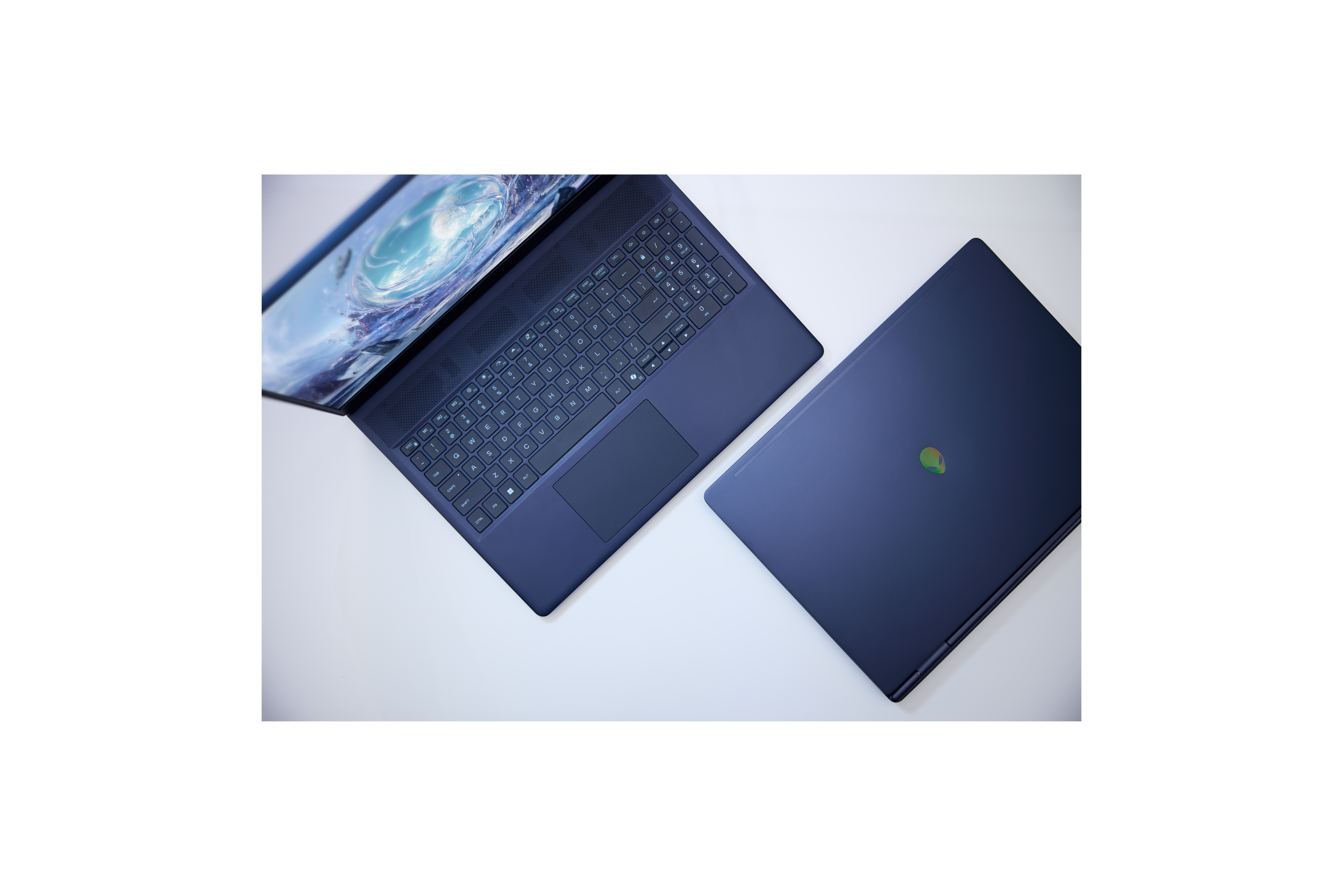 The Alienware 16 Aurora H and HX Gaming Laptops on a coffee table with keys and a backpack. 