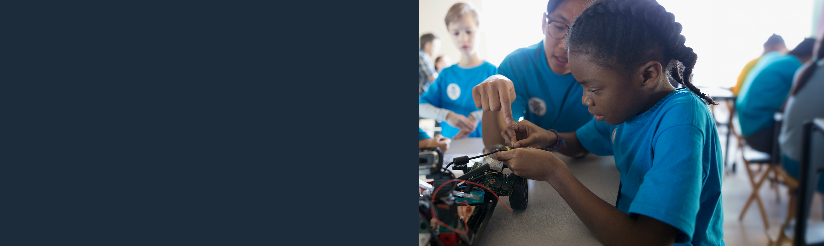 School girl wiring electronics for a model car in the classroom
