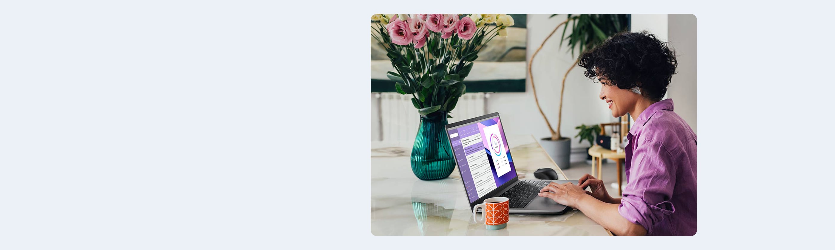 A side view of a beautiful Latin American entrepreneur smiling while watching something on her laptop, floral arrangement on desk with the screen show