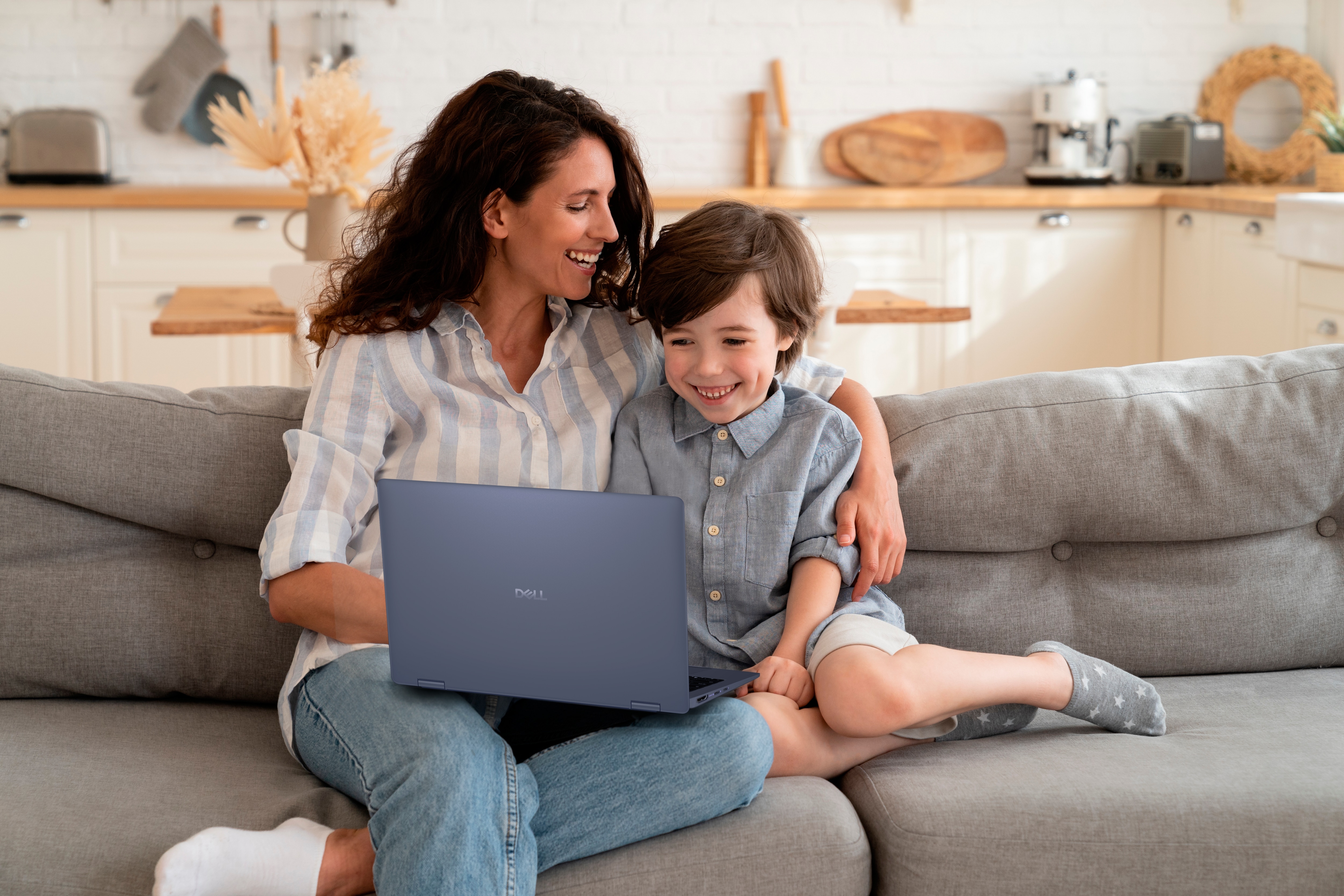 Joyful Mother relaxing after work with preschool son on the couch.