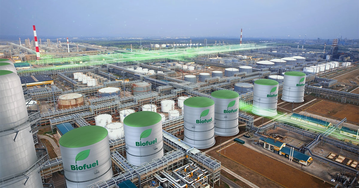 Aerial view of a large industrial biofuel production facility with numerous silver cylindrical storage tanks labeled biofuel.