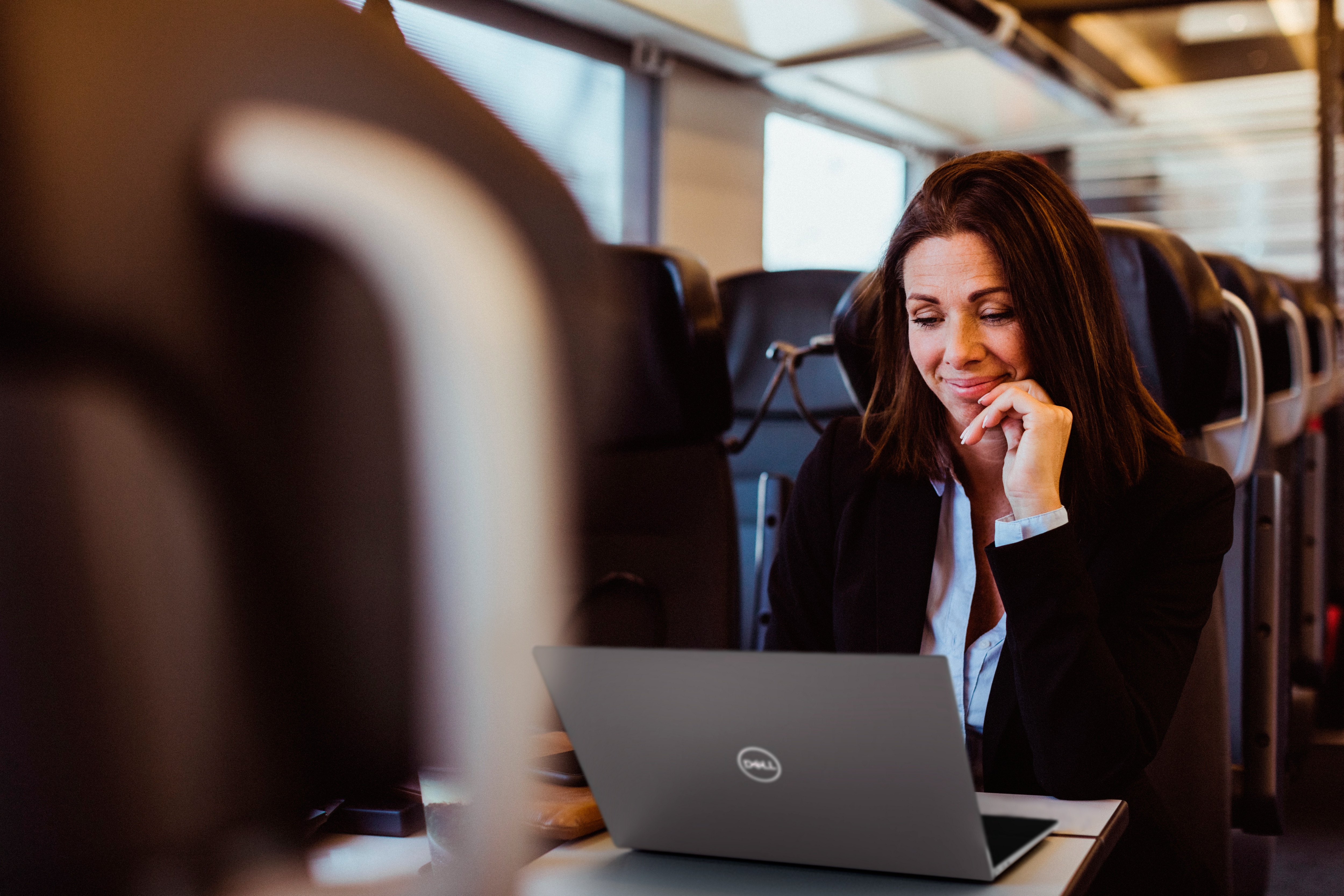 Businesswoman Using Laptop Sitting in Train