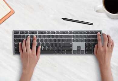 Bild von auf einer Dell Mehrgeräte-Wireless-Tastatur KB700 tippenden Händen.