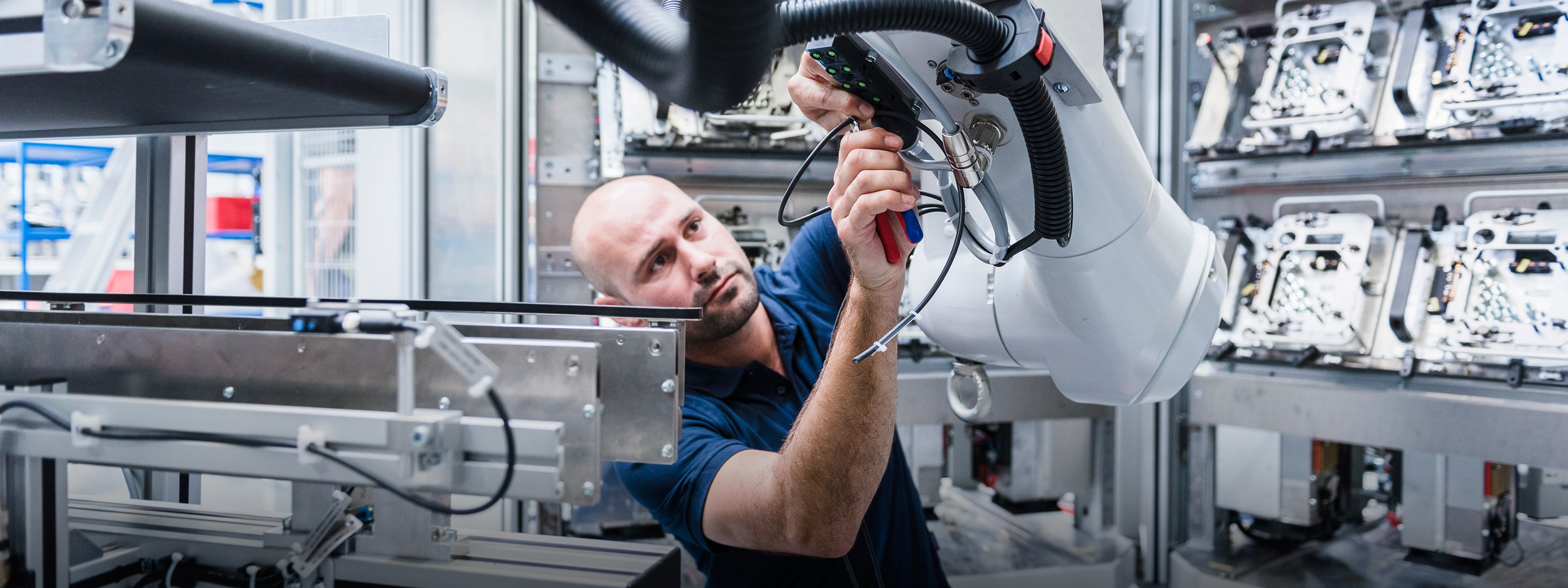 Factory technician works on a robotic manufacturing arm