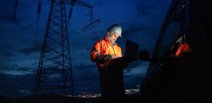The grid modernization. Mature engineer works in electrical utility services. Night shift.