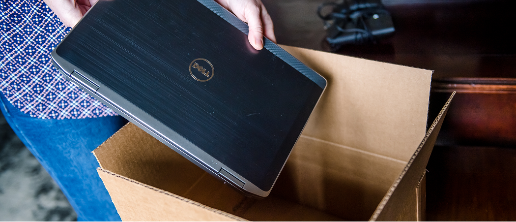 A Dell laptop being placed in a box to send in for recycling.