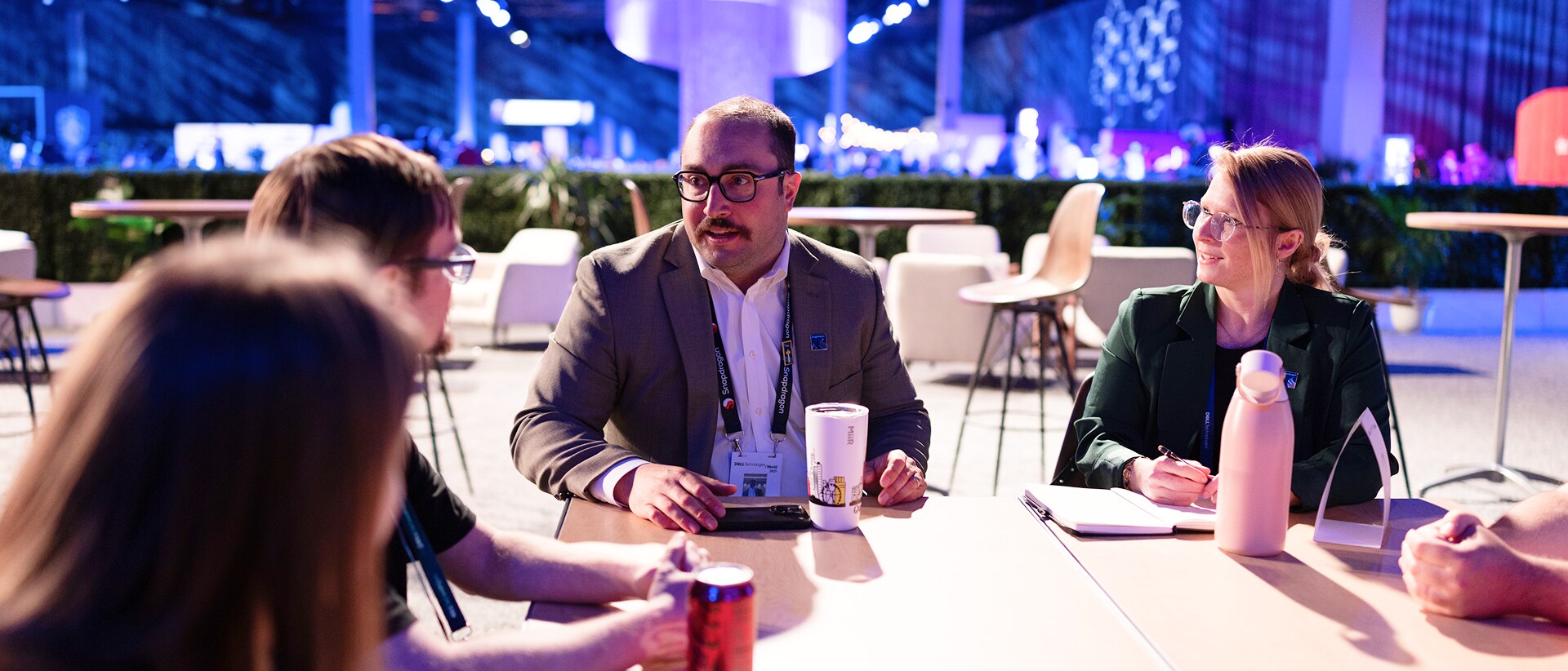 Four conference attendees sitting around a table in discussion
