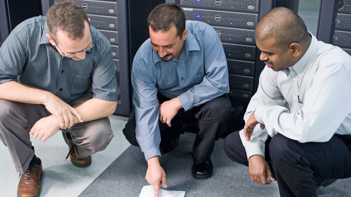 Tehnicians Crouching Down in Front of a Network Server