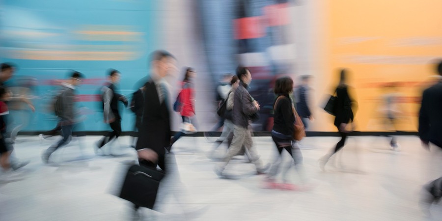 People Passing Colorful Billboards