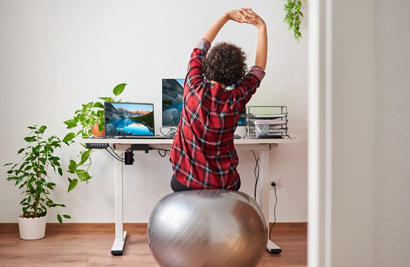 En kvinna som stretchar medan hon tränar på en fitball