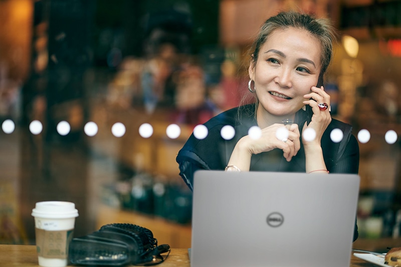 Mid adult Asian Business Woman Working in Coffee Shop