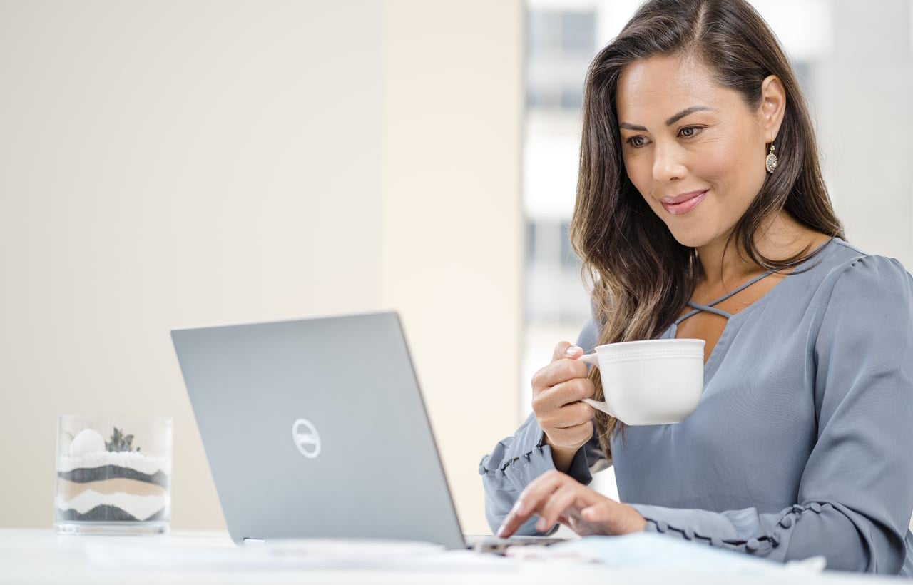 Une femme asiatique travaille sur un ordinateur portable avec du café