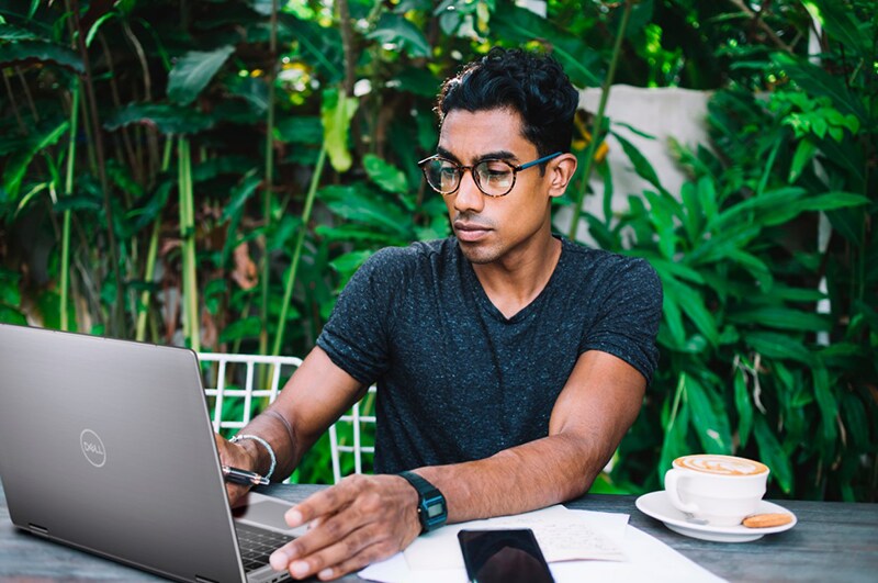 Professional using Laptop while Sitting at Table at Street Cafe