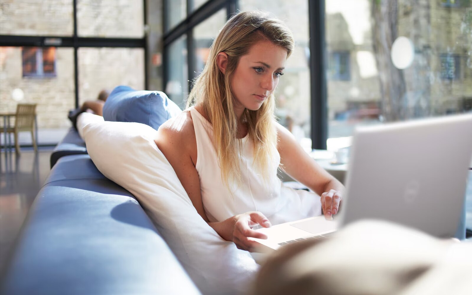 Woman on couch using Laptop in an office