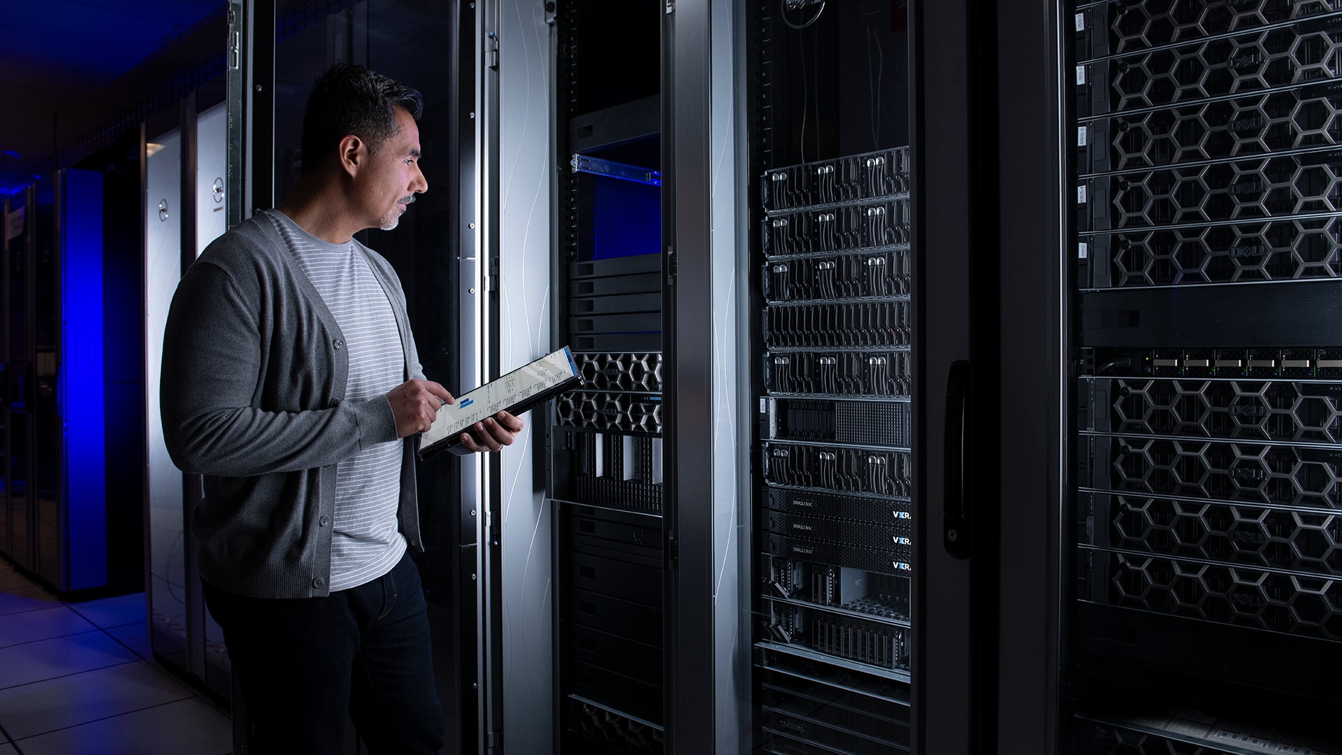 Man Standing While Working On Servers In Data Center 