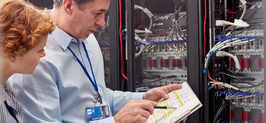 IT Technicians with Clipboard Examining Panel in Server Room