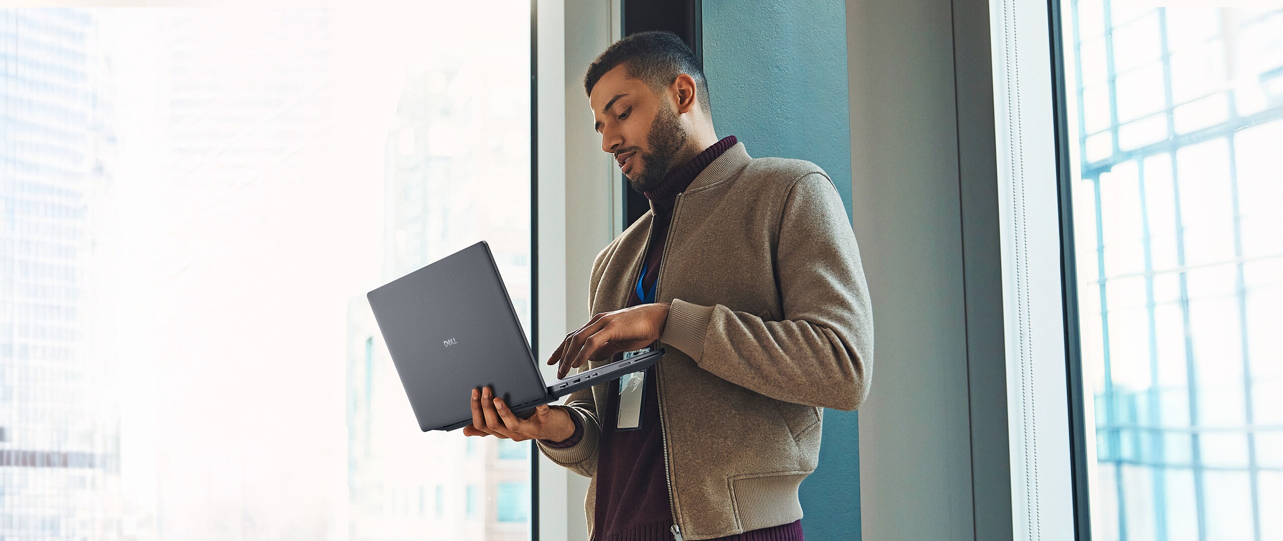 A man standing while working on a Dell Pro Max laptop.
