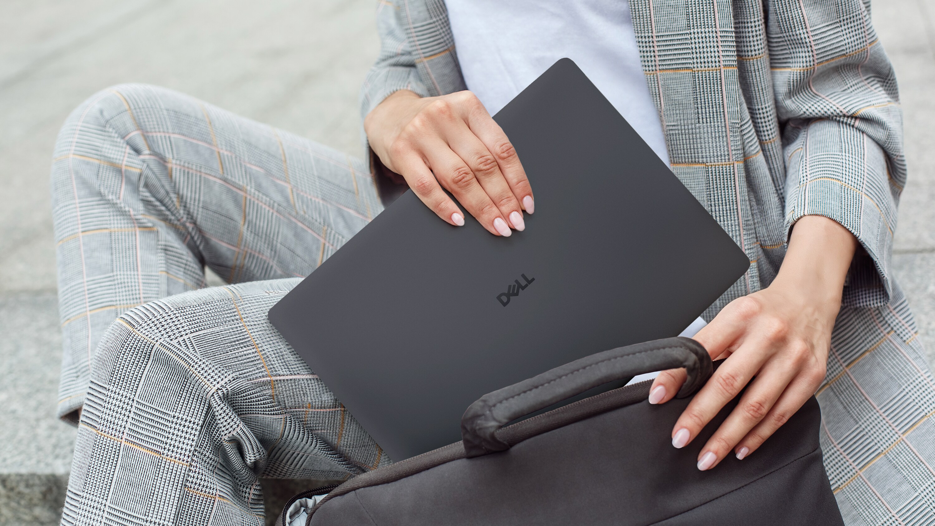Person putting Dell Pro 14 inside bag.