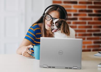 Picture of a woman with a headset on her head and a dog in front of a Dell Inspiron 14 7420 2-in-1 laptop.