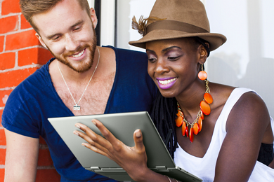 Picture of a smiley man and woman. The woman is with an Inspiron 14 7425 on her left hand, showing the screen to the man.