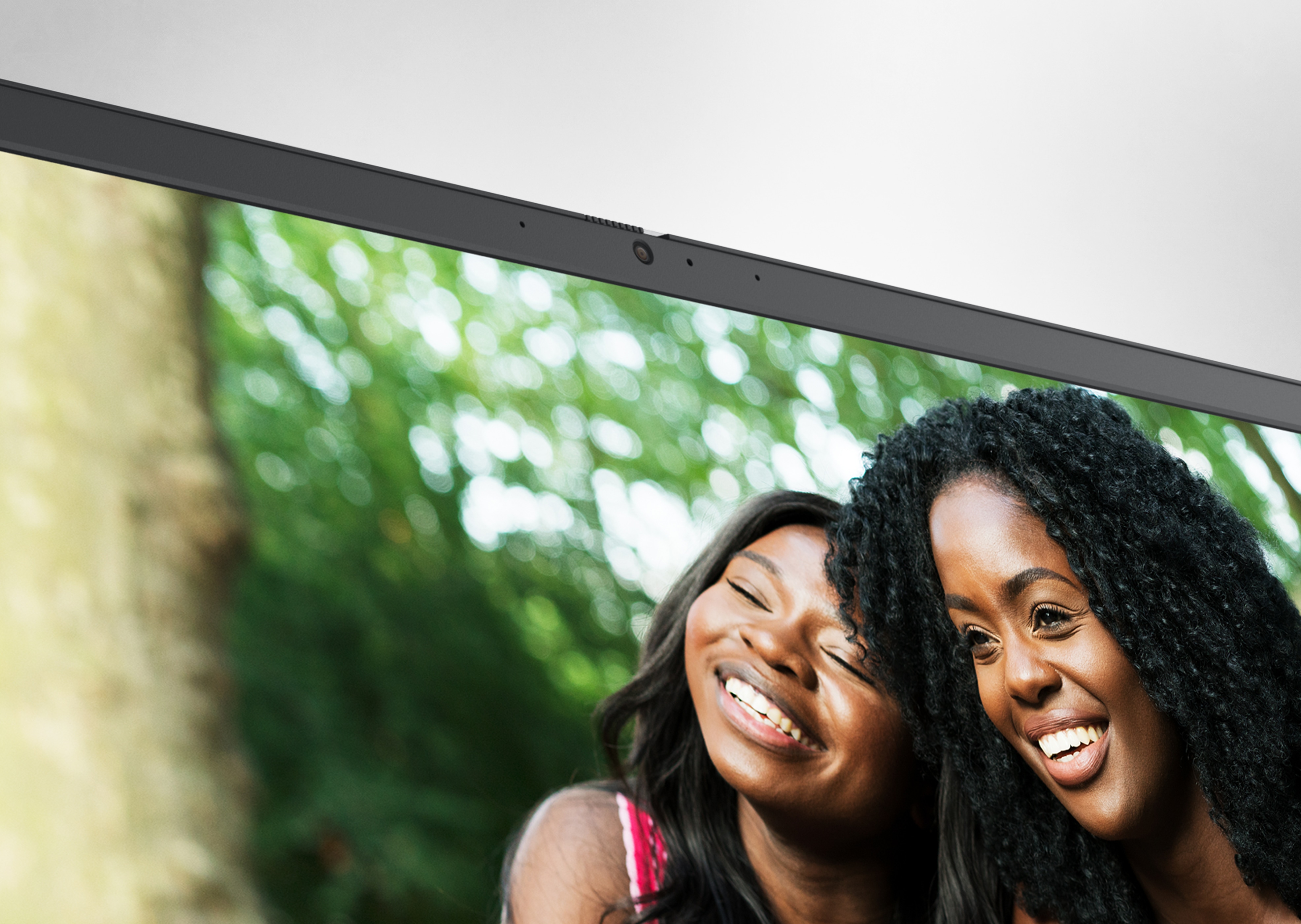 Photo d’un écran d’ordinateur portable Dell Inspiron 15 3525 avec deux filles souriantes côte à côte.