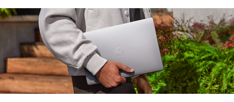 Manos masculinas sosteniendo una computadora portátil Dell XPS 13 9340.