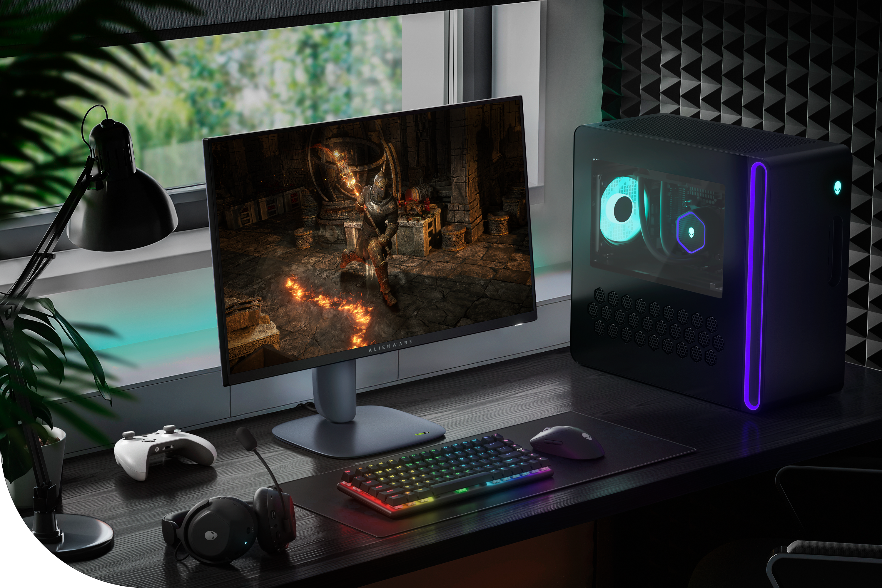 The Alienware 27 Gaming Monitor at a gaming desk setup with a desktop, headphones, game controller, keyboard and mouse