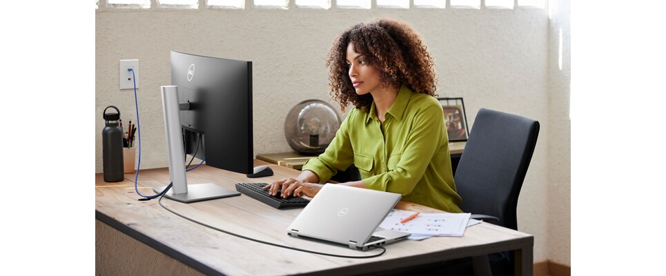 Woman using Dell products at table in front of her.