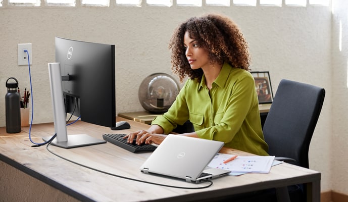 Woman using Dell products at table in front of her.