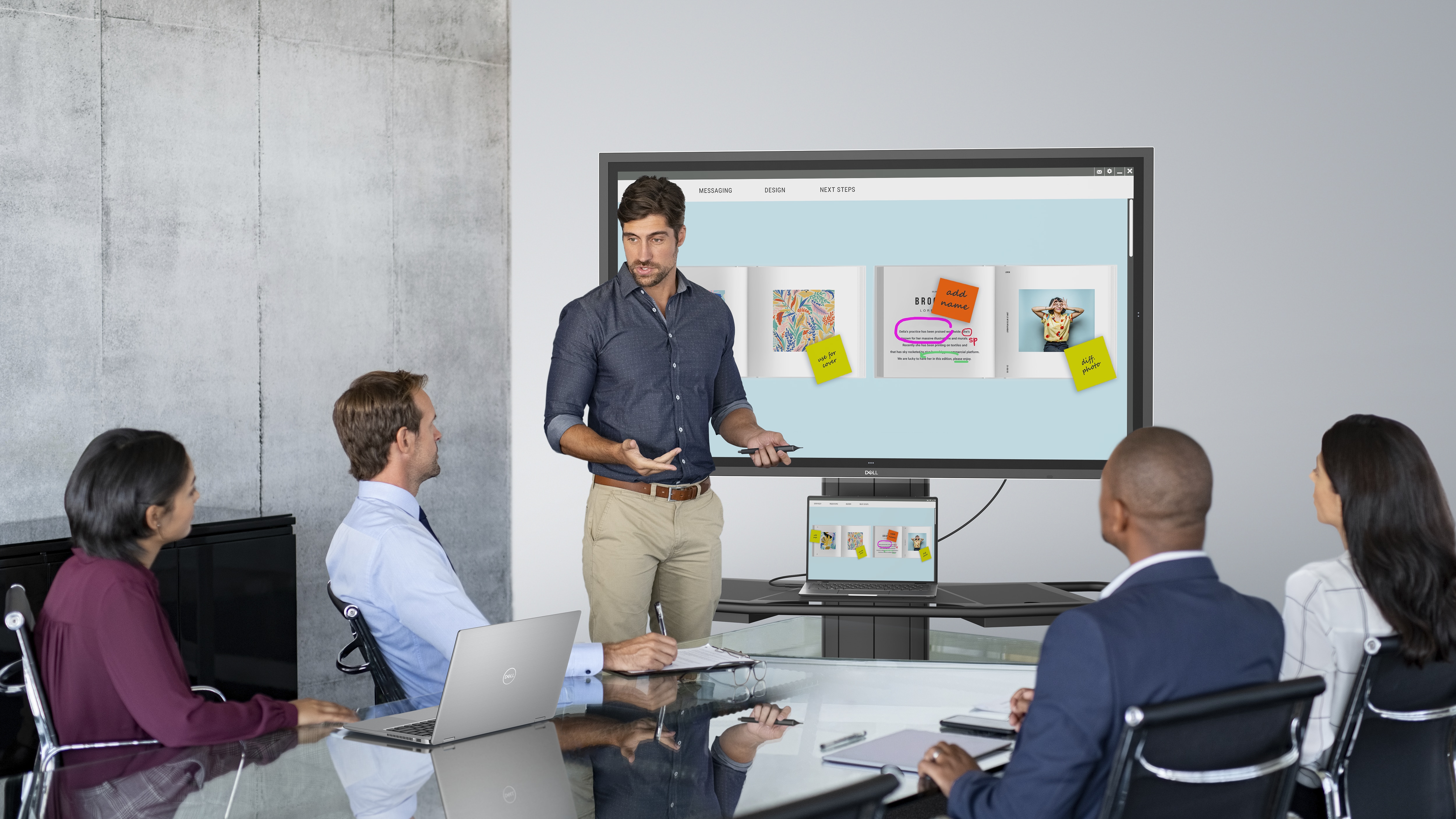 Group of people in a meeting room and a man presenting metrics on a Dell P5524QT Interactive Touch Monitor.