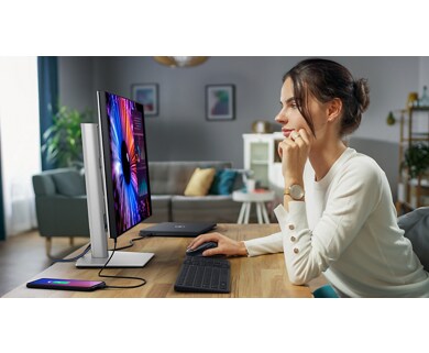 Woman leaning on a table using Dell products.