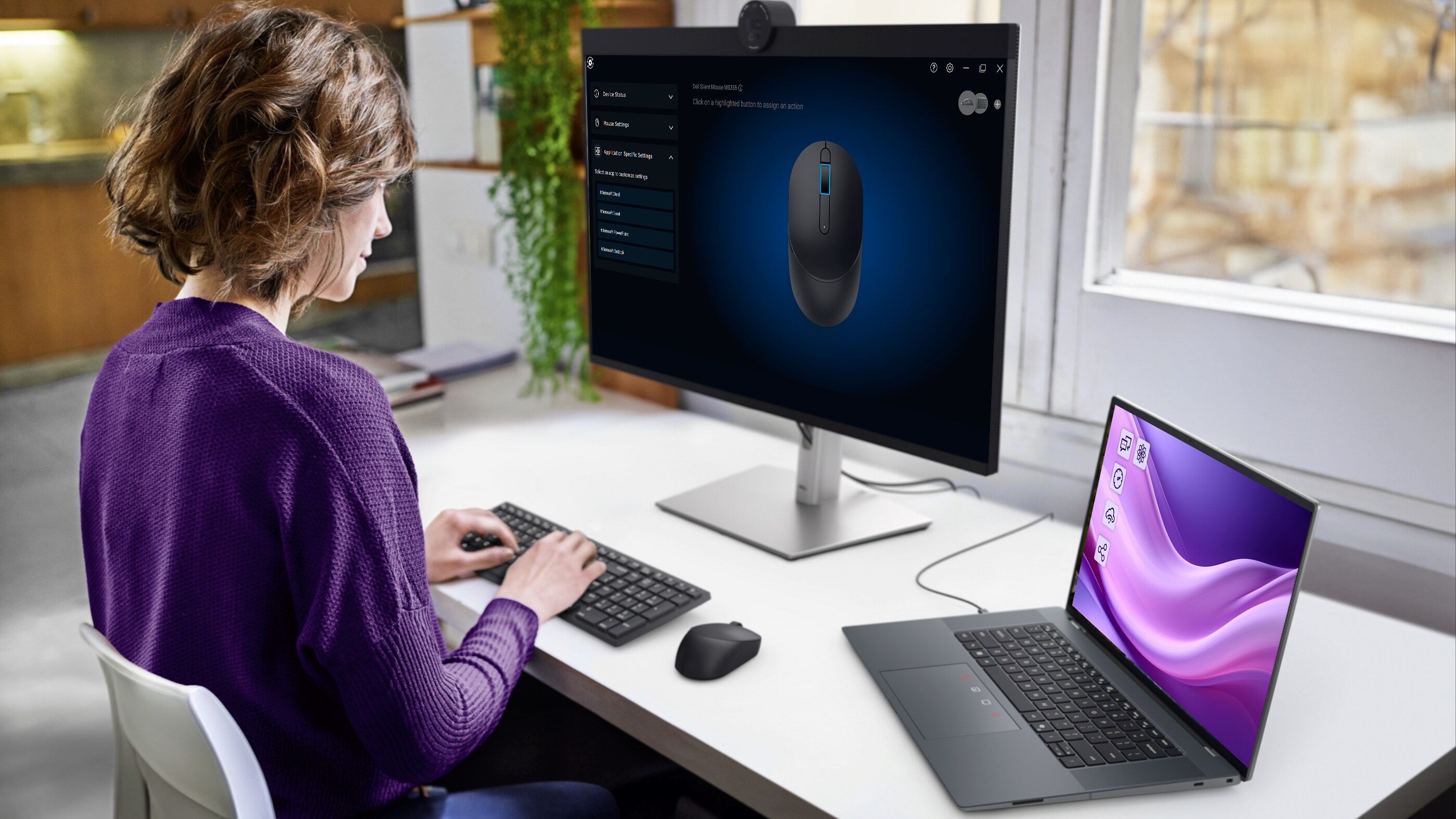 A monitor and laptop connected to the silent keyboard and mouse.