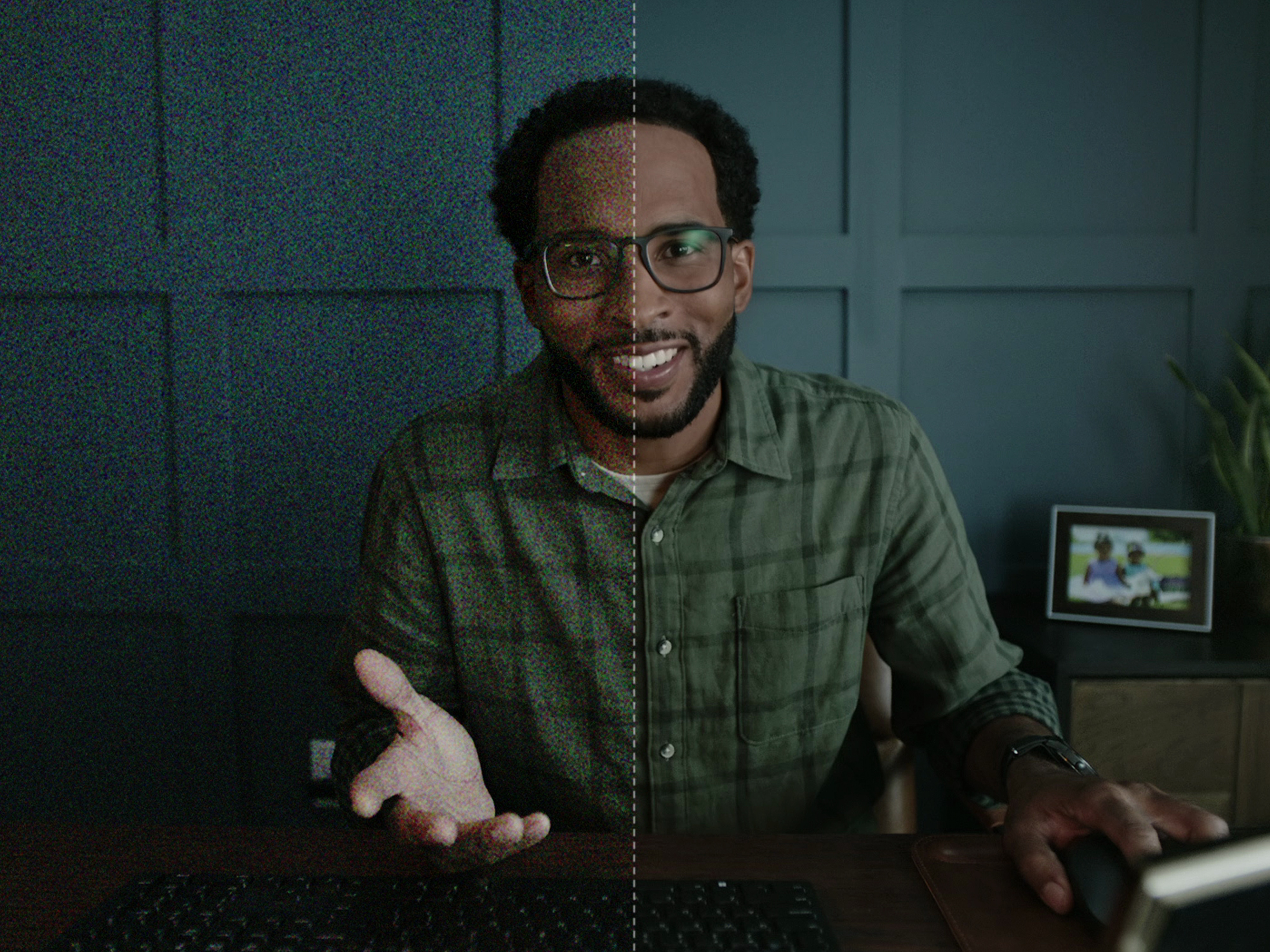 Man wearing glasses with his left hand resting on a keyboard.