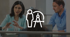 Man and woman sitting in an office talking.