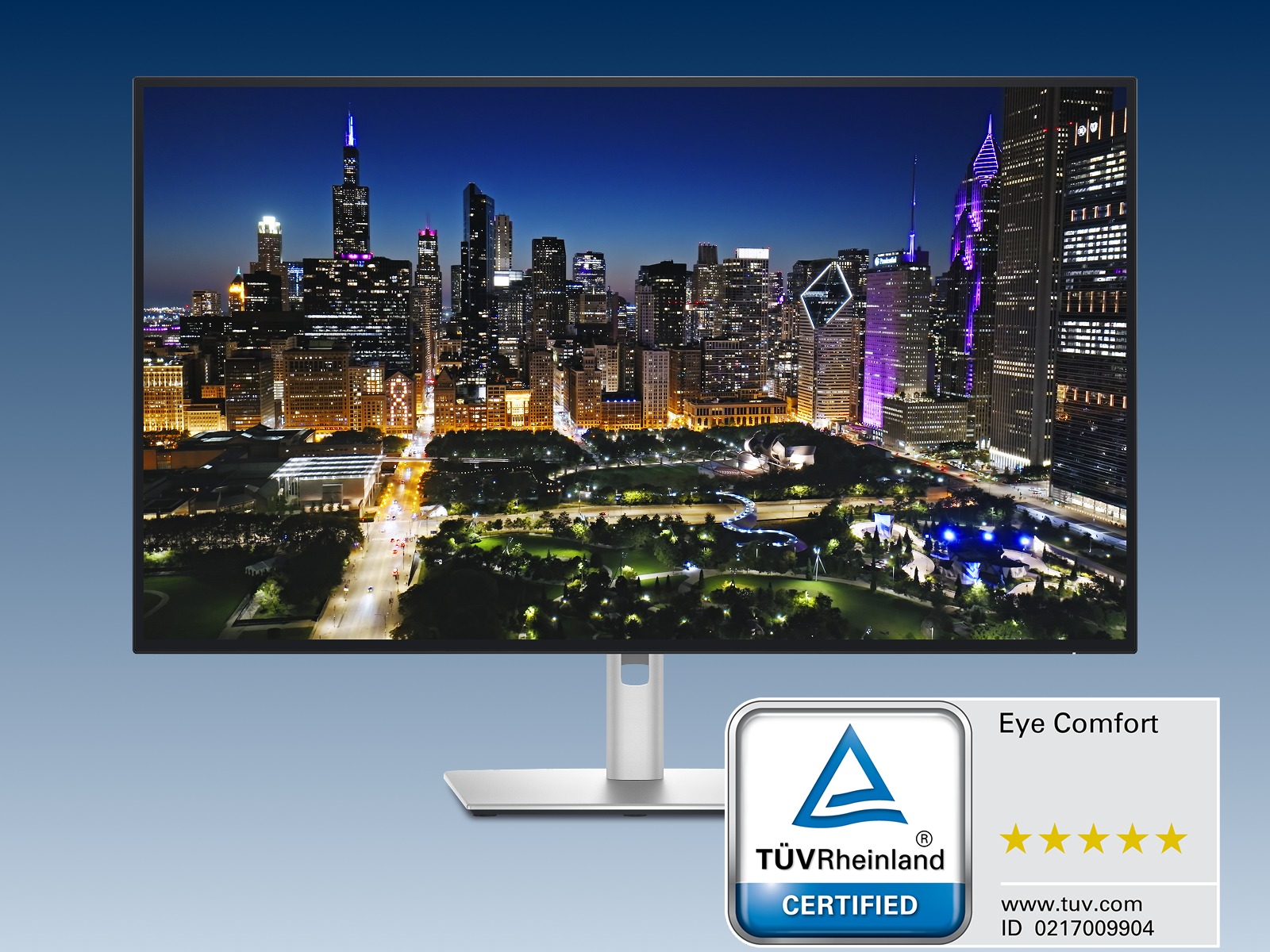 Un écran Dell, avec une ville animée la nuit, sur un fond gris bleu