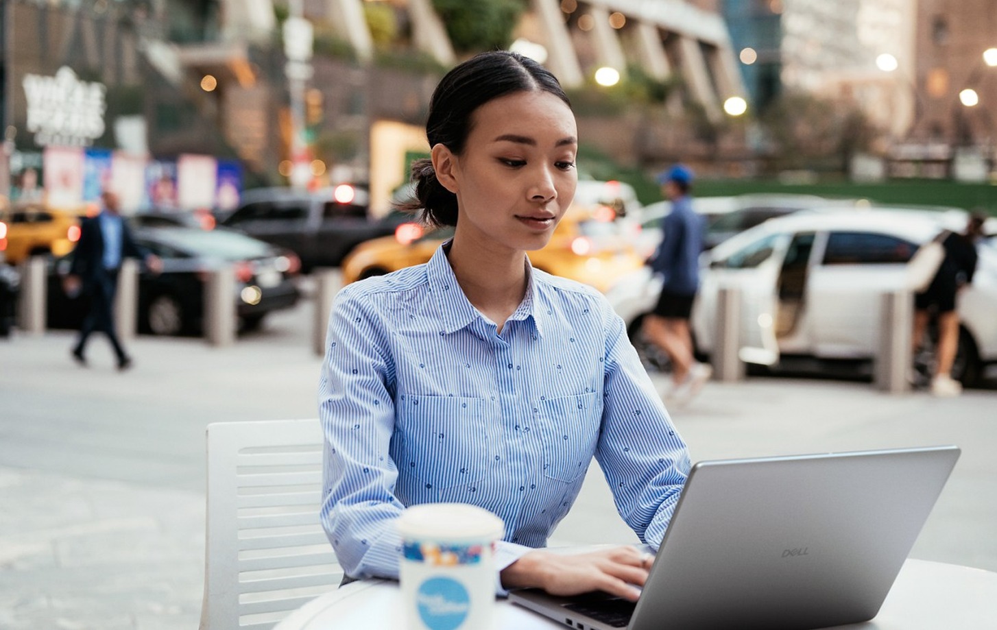 Woman using a laptop in an outdoor cafe