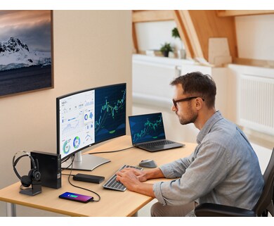 Man sitting on an office chair typing on a keyboard and looking to a Dell UltraSharp U3423WE monitor.